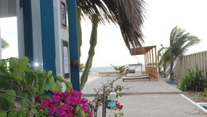 Un paseo marítimo con un banco de madera, un farol y vistas al mar.