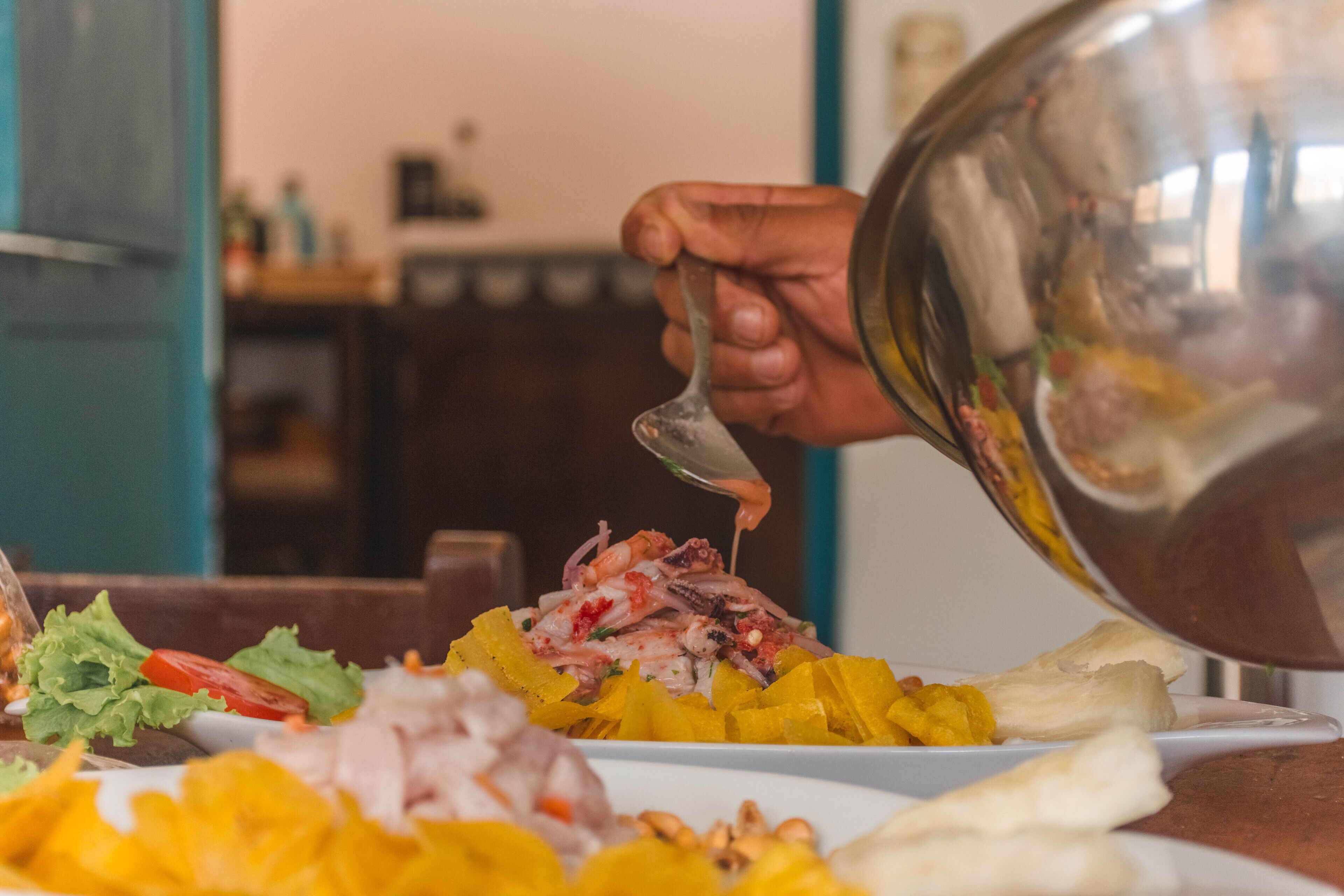 Une personne versant une sauce sur un plat de fruits de mer.