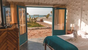 Una habitación con cama, escritorio y vista a la playa.