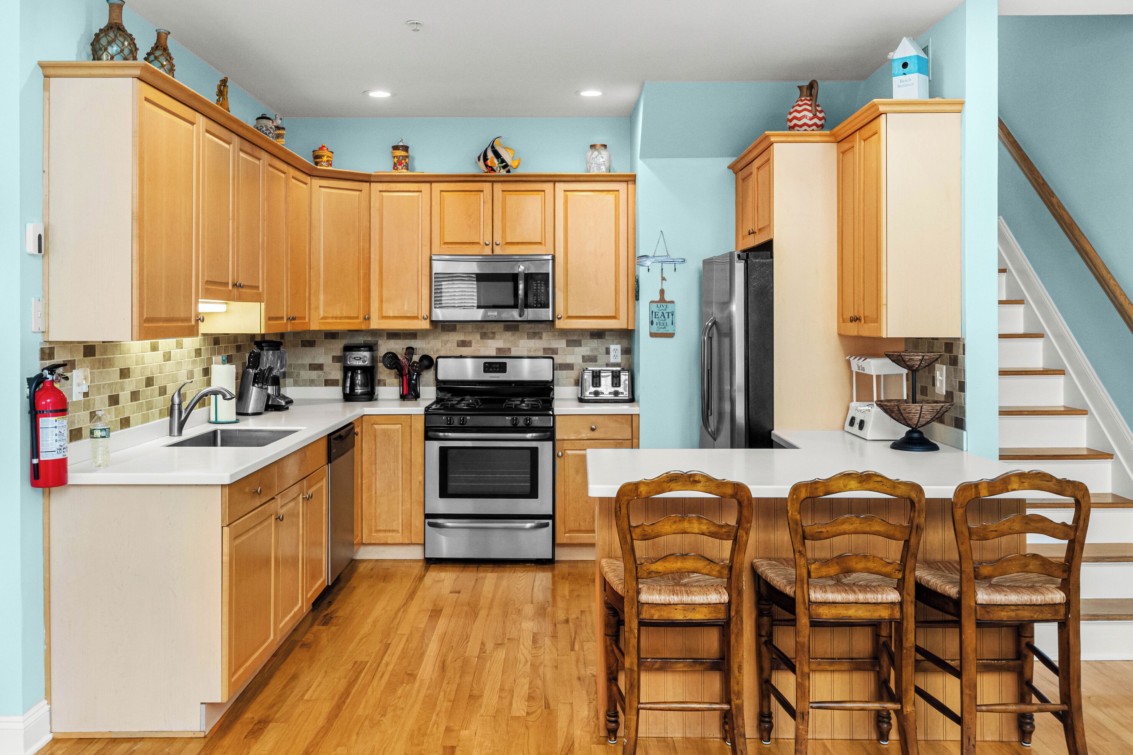 Una cocina con armarios de madera, una estufa de acero inoxidable, un microondas y un refrigerador.