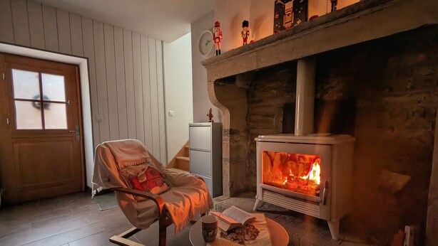 A cozy living room with a stone fireplace, a wooden door, and a comfortable chair.