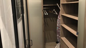 A walk-in closet with open doors, shelves, and a hanging rod. - CANNES APPART. LUXURY 50 m2 HYPER CENTER (Cannes)
