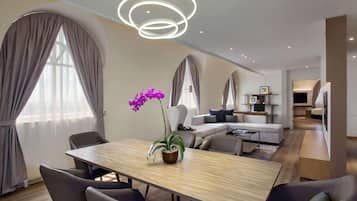 Een moderne hotelkamer met een zithoek, een zette en een televisie.