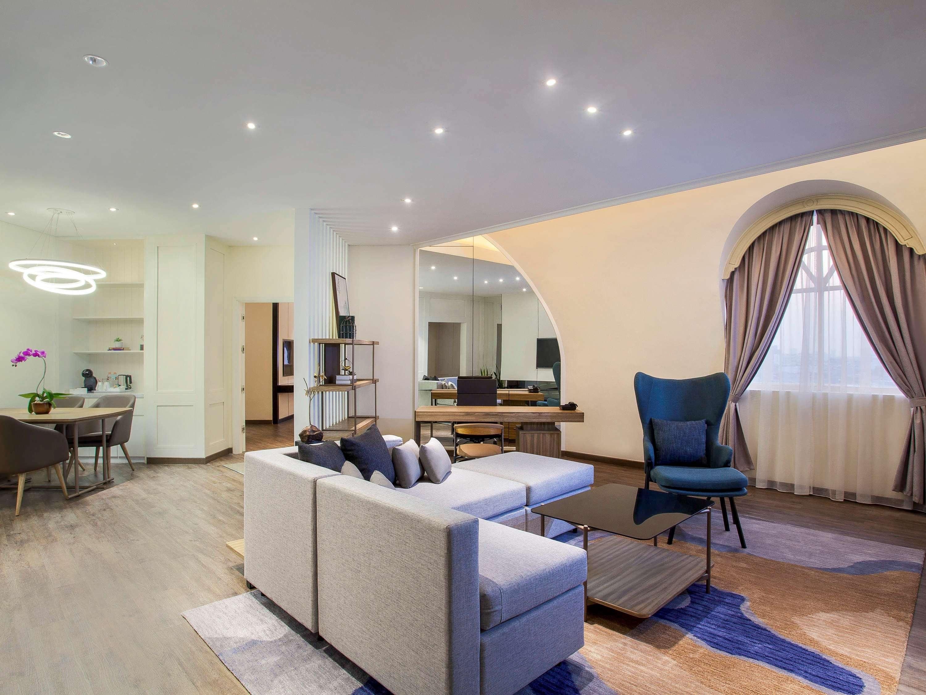 Un salon moderne comprenant un canapé, une table basse et un coin repas avec une table et des chaises.