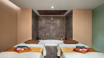 Una habitación con dos camas, una bañera y una ducha.