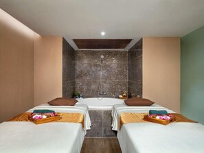 Una habitación con dos camas, una bañera y una ducha.
