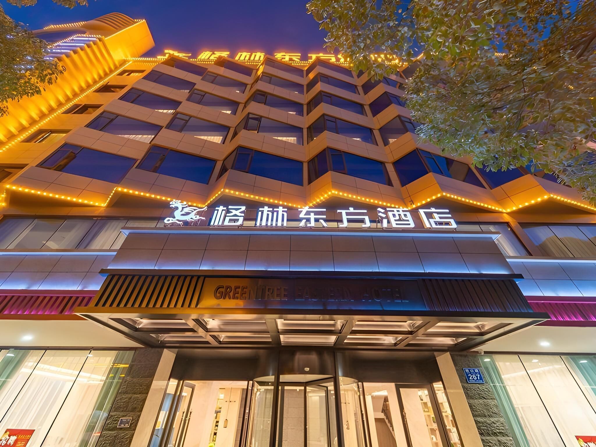 Un hotel de diseño moderno, con un letrero destacado que muestra caracteres chinos y un logotipo.