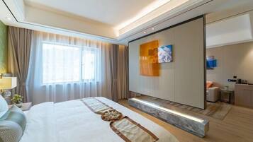 Una habitación de hotel moderna con una cama grande, un vestidor, un baño y vistas a la ciudad.