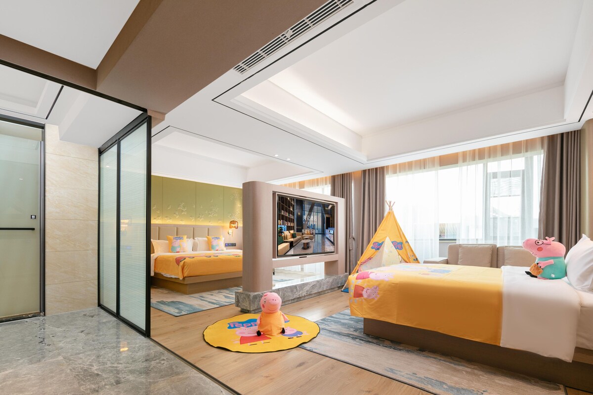 Una habitación de hotel con cama, televisión, ventana con cortinas, sofá y una tienda pequeña.