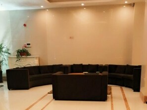 Una sala de estar moderna con un sofá modular, una mesa de centro y una chimenea.