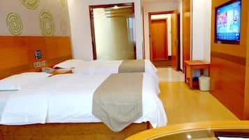 Una habitación de hotel con una cama grande, un televisor y piso de madera.