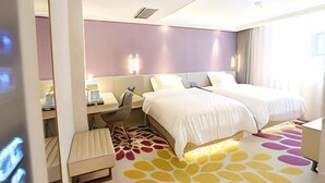 A hotel room with a bed, desk, chair, and a patterned floor. - Lavande Hotel (Guilin Longsheng) (Longsheng)