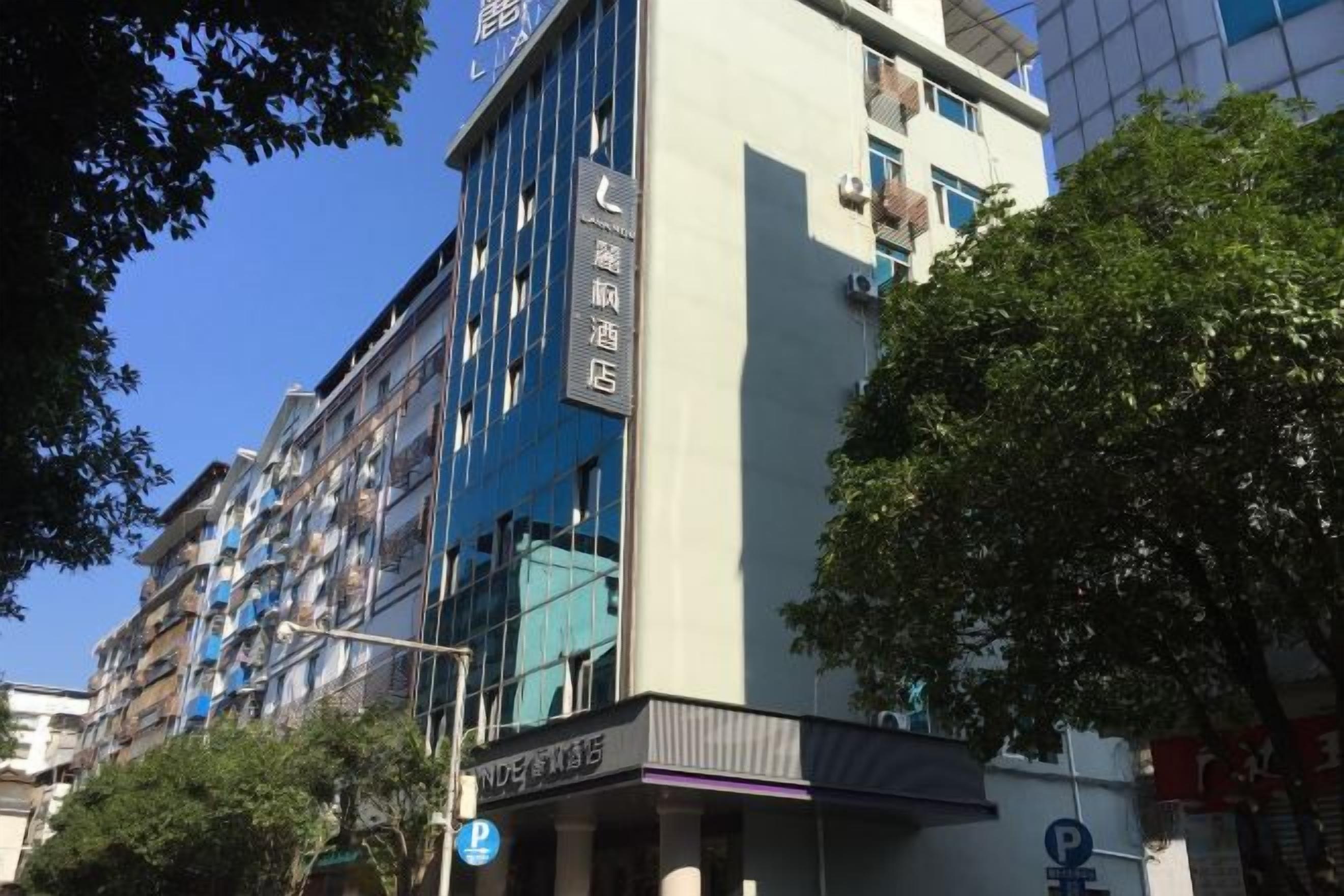 A multi-story hotel with a modern facade, featuring balconies and large windows.