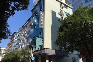 A multi-story hotel with a modern facade, featuring balconies and large windows.