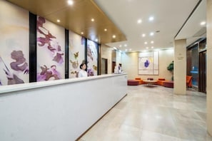 A reception area with a long counter, a seating area with orange chairs, and a wall with animal illustrations.
