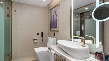 A modern bathroom with a large sink, a mirror, and a shower.