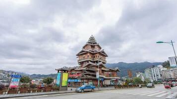 A traditional multi-tiered building with a modern street in front.
