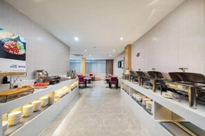 Un buffet avec plusieurs postes de service et des espaces où les clients peuvent s’asseoir pour manger.