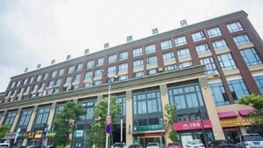 Un edificio comercial de varios pisos con grandes ventanales y varias entradas.