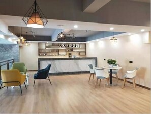 A modern dining area with a marble countertop, wooden chairs, and pendant lighting. - Greentree Inn Yinchuan International Trade Market (Yinchuan)