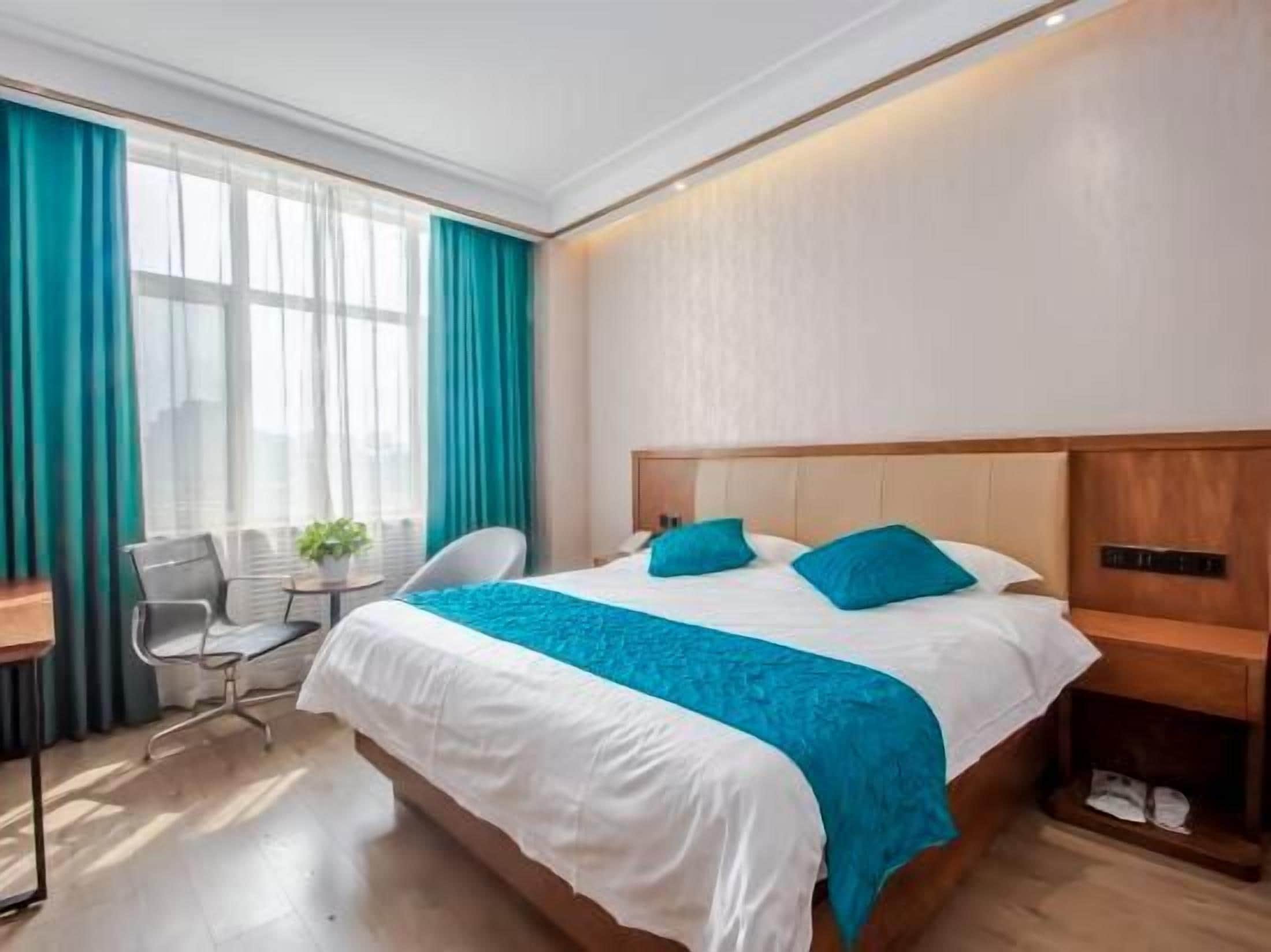 Una camera d'albergo con un letto grande, una scrivania e una sedia.