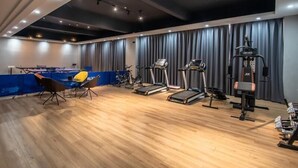Un gimnasio amplio con cintas de correr, una bicicleta estática y una máquina de pesas.