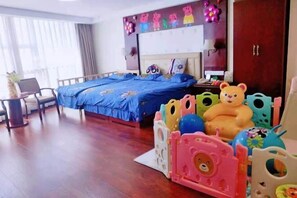 Cozy retreat with a large bed, desk, and playpen, perfect for families.