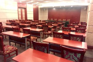 A conference room with multiple tables and chairs arranged for meetings.