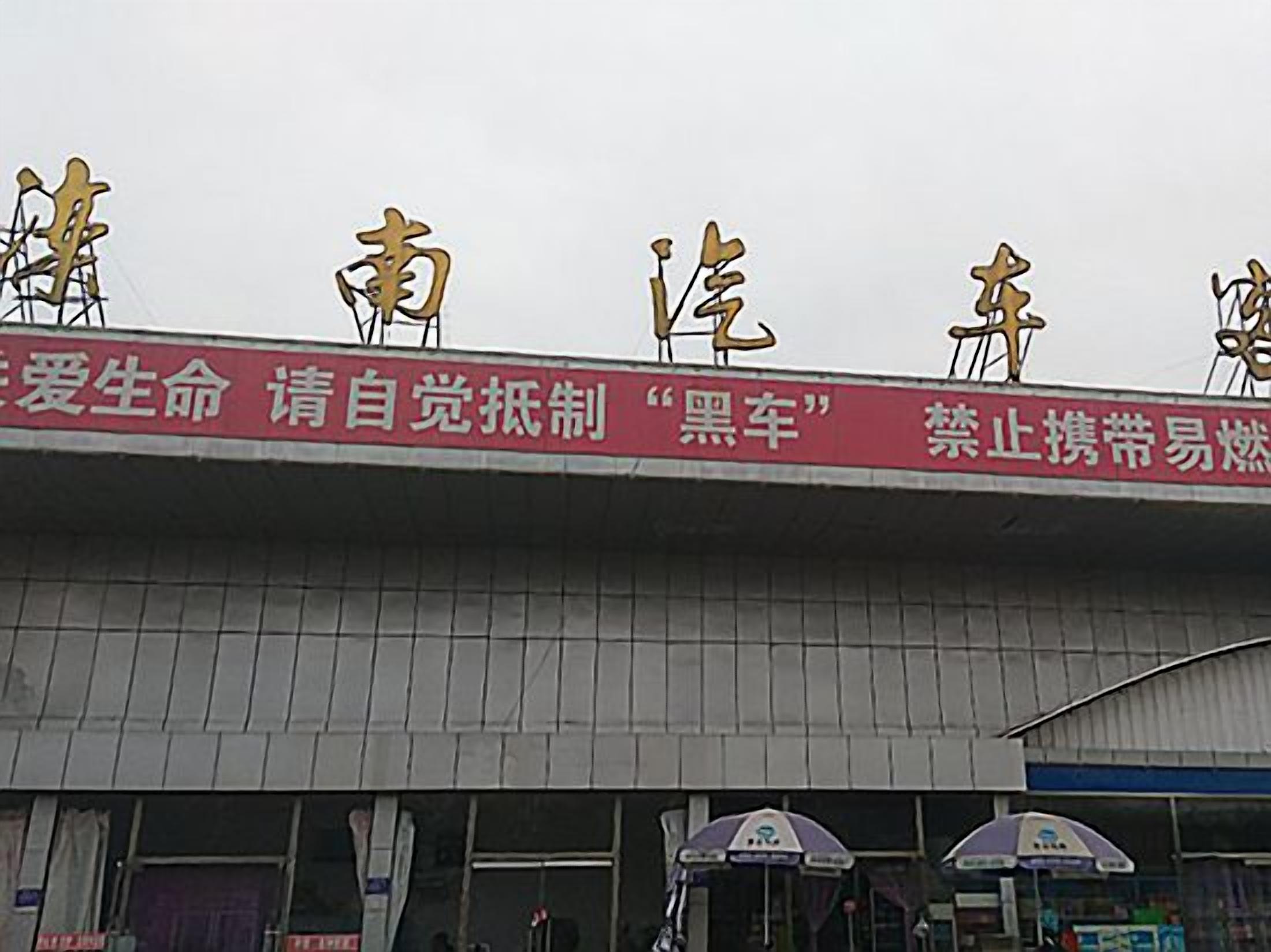 Un edificio con un cartel rojo que muestra caracteres chinos y un letrero de tienda.