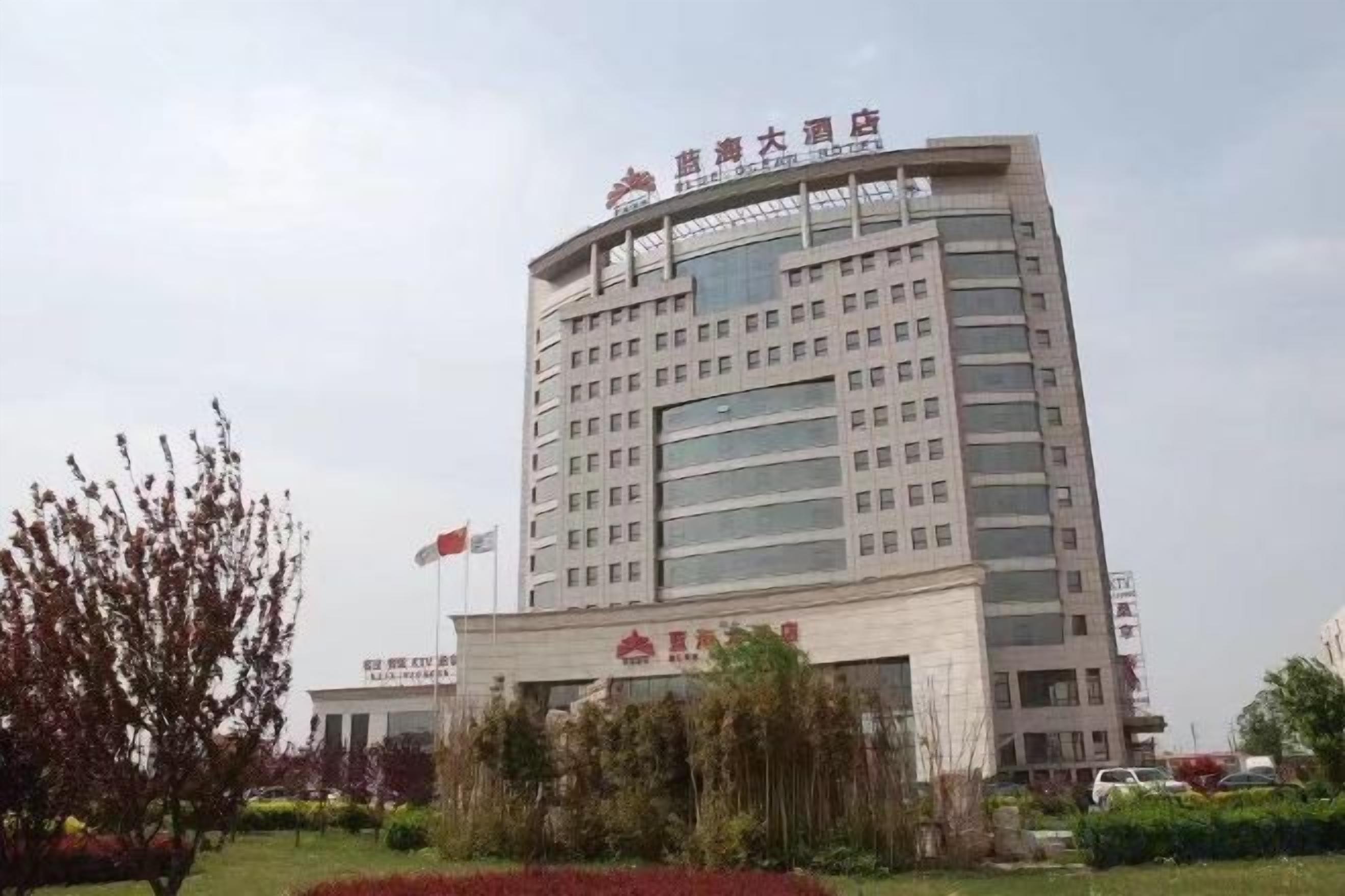A multi-story hotel with a prominent entrance and a flagpole.