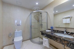 Un baño con inodoro, lavamanos, ducha y espejo.