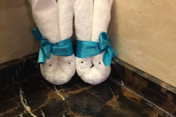 Un par de pantuflas blancas con cintas teal atadas a los tobillos.