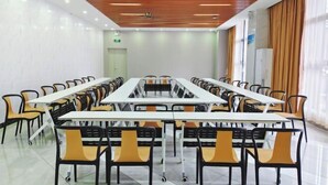 A conference room with a long table and chairs, white walls, and a wooden ceiling. - GreenTree Inn (Qionghai Boao High-speed Railway Station) (Qionghai)