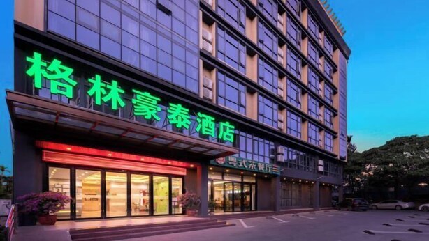 A hotel with a modern facade, large windows, and a prominent green sign. - GreenTree Inn (Qionghai Boao High-speed Railway Station) (Qionghai)