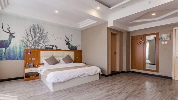 Une chambre spacieuse avec un grand lit, une tête de lit en bois, une table de chevet et un miroir fixé au mur.