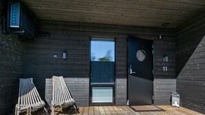 A wooden deck with two lounge chairs, a door, and a small outdoor area with a bench. - Kasnäs marina b11 by Interhome (Kemiönsaari)