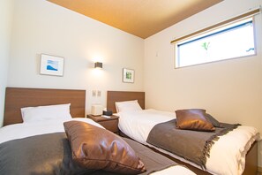 A hotel room with two beds, a nightstand, a bedside table, and a window with a view.