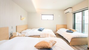 Quarto de hotel com duas camas, uma janela e um ar condicionado.