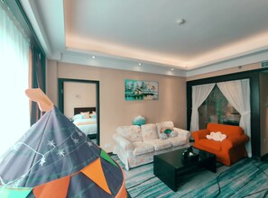 A hotel room with a bed, a sofa, a chair, a small table, and a tent-like play area. - Dongshan Hotel, Guangzhou (Guangzhou)