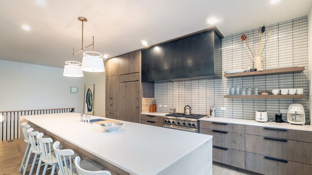 A modern kitchen with a large island, bar stools, a gas stove, and a tiled backsplash. - SAN JUAN 103- Newly-Built, Masterfully Finished Jewel near Gondola, Shops, Resta (Telluride)