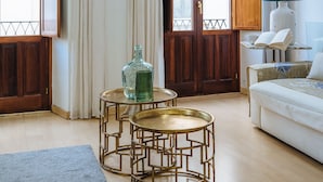A living room with a sofa, two round tables, a lamp, and a window with curtains. - Deluxe Penthouse Giralda Views, 3Bd 2Bt, 7 people, Parking optional (Sevilla)