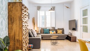 Un salon moderne comprenant un canapé, un meuble en bois, un téléviseur et un coin repas.