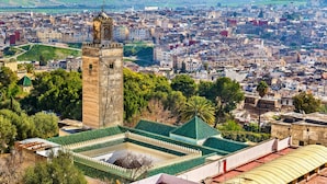 A cityscape with a prominent tower, dense urban buildings, and a green-roofed structure. - Room in Guest Room - Beautiful Riad Ouliya in Fès (Fes)