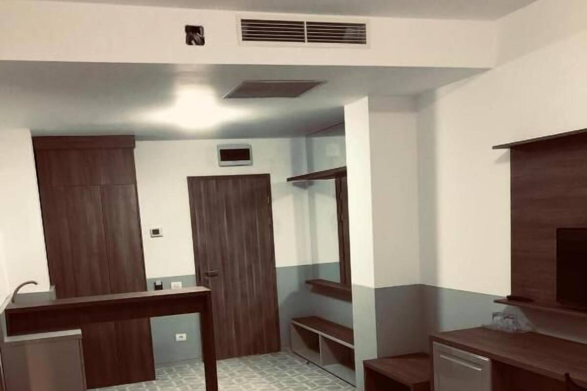Un espacio habitable pequeño con kitchenette, un sofá y un comedor.