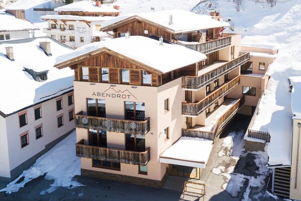 A multi-story hotel with balconies and a ski slope in the background. - Hotel Abendrot by Alpeffect Hotels (Ischgl)