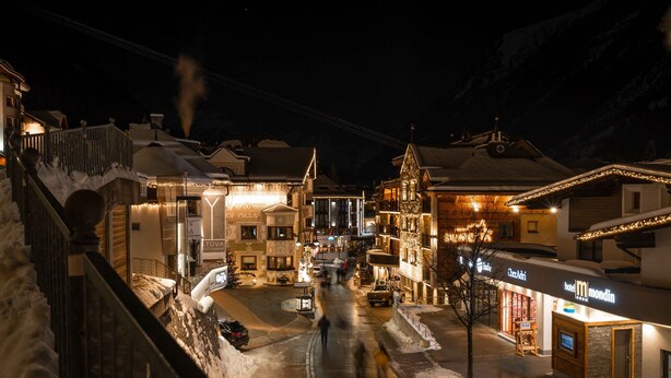 A snow-covered street with buildings, including a hotel named "Hotel Mondin" and a restaurant "Tovosa." - Hotel Abendrot by Alpeffect Hotels (Ischgl)