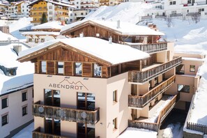 A multi-story building with balconies and a mountain logo, surrounded by snow. - Hotel Abendrot by Alpeffect Hotels (Ischgl)