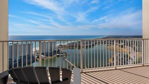 A balcony with a view of a coastal area, including buildings and a body of water. - ☀️By Beach in Seascape-Wow!22nd FL Gulf Views-3 Pools-2BR Ariel Dunes II 2203☀️ (Destin)