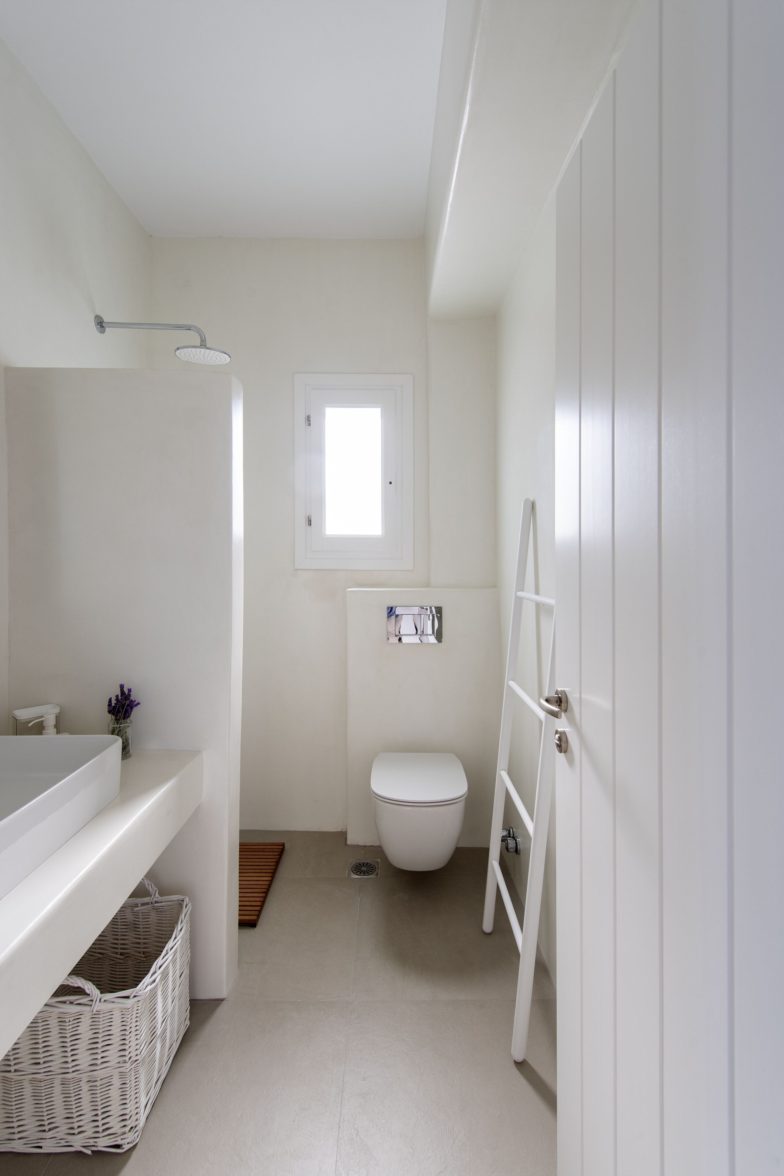 Un baño pequeño con lavamanos blanco, inodoro y ducha.
