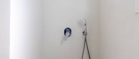 A shower with a handheld showerhead and a wall-mounted rain showerhead.